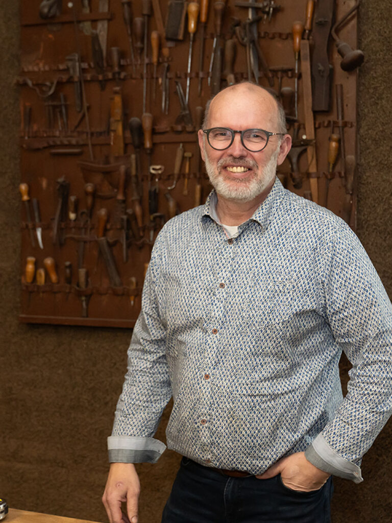 Corné achter de toonbank met gereedschap van de oprichter Sander van der Velden.