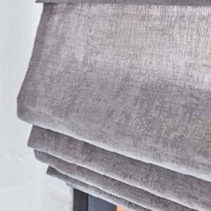 Detail van een vouwgordijn met zichtbare plooien en baleinen.