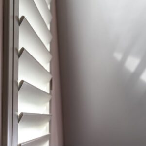 Close-up van witte shutters met verstelbare lamellen.