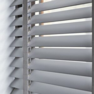 Detailfoto van houten jaloezieën met openstaande lamellen.